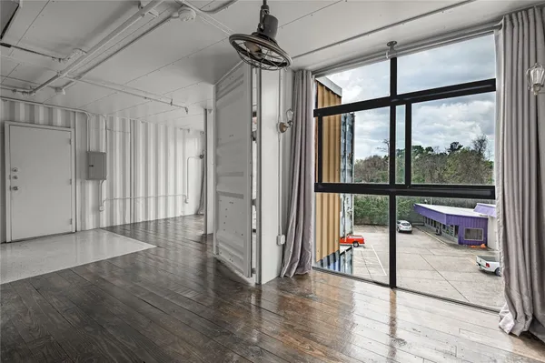 a view of a hallway with wooden floor and cabinet