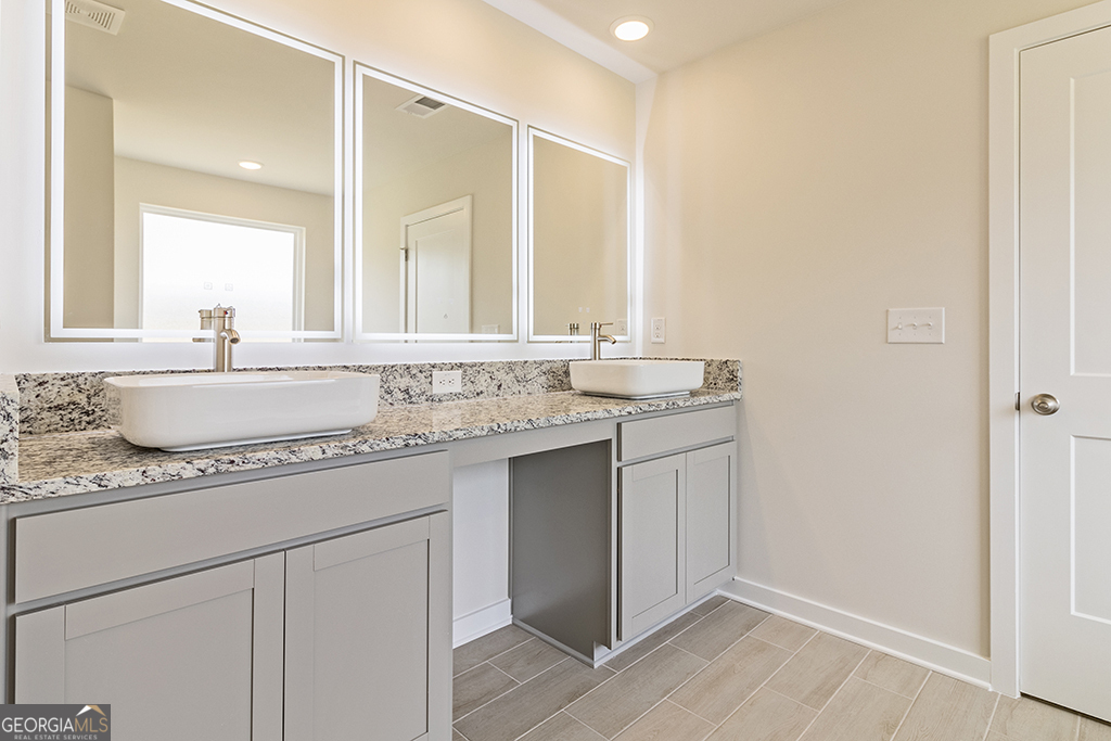 337 Jarrett Street, Unit 150 Fairburn, GA 30213 - Photo 26 of 32 a bathroom with a granite countertop sink and a mirror