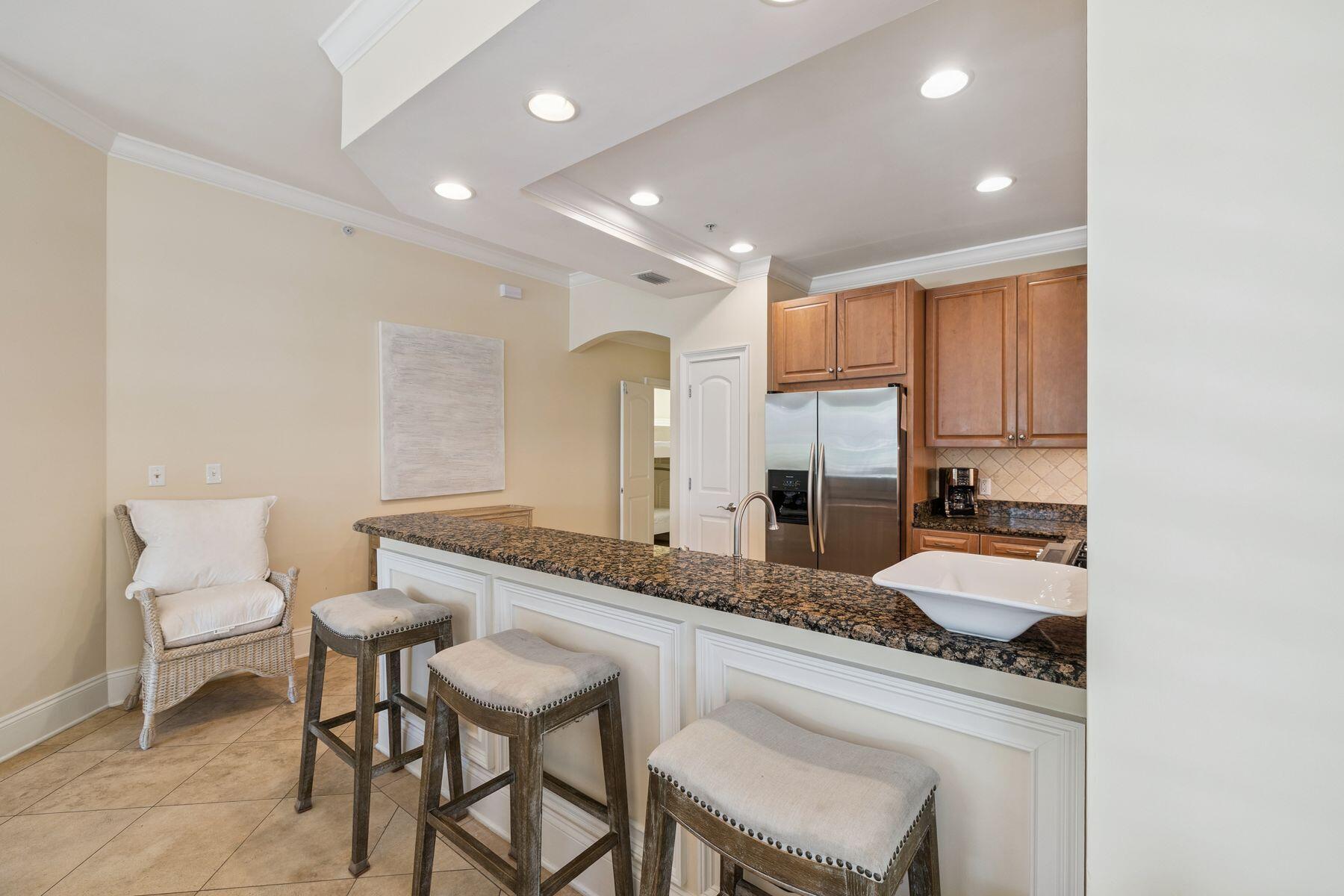 2421 West County Highway 30A, Unit D101 Santa Rosa Beach, FL 32459 - Photo 24 of 44 a kitchen with granite countertop sink and chairs