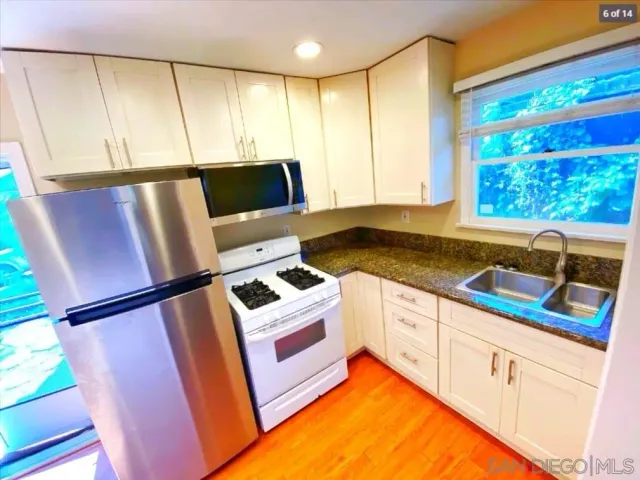 a kitchen with a sink appliances and cabinets