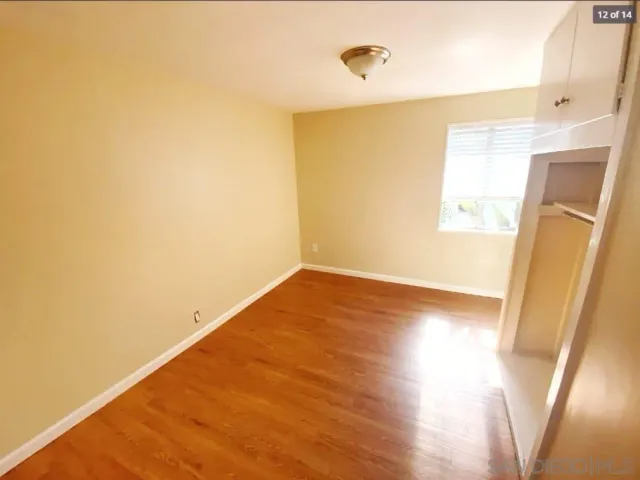 a view of a room with wooden floor and a window
