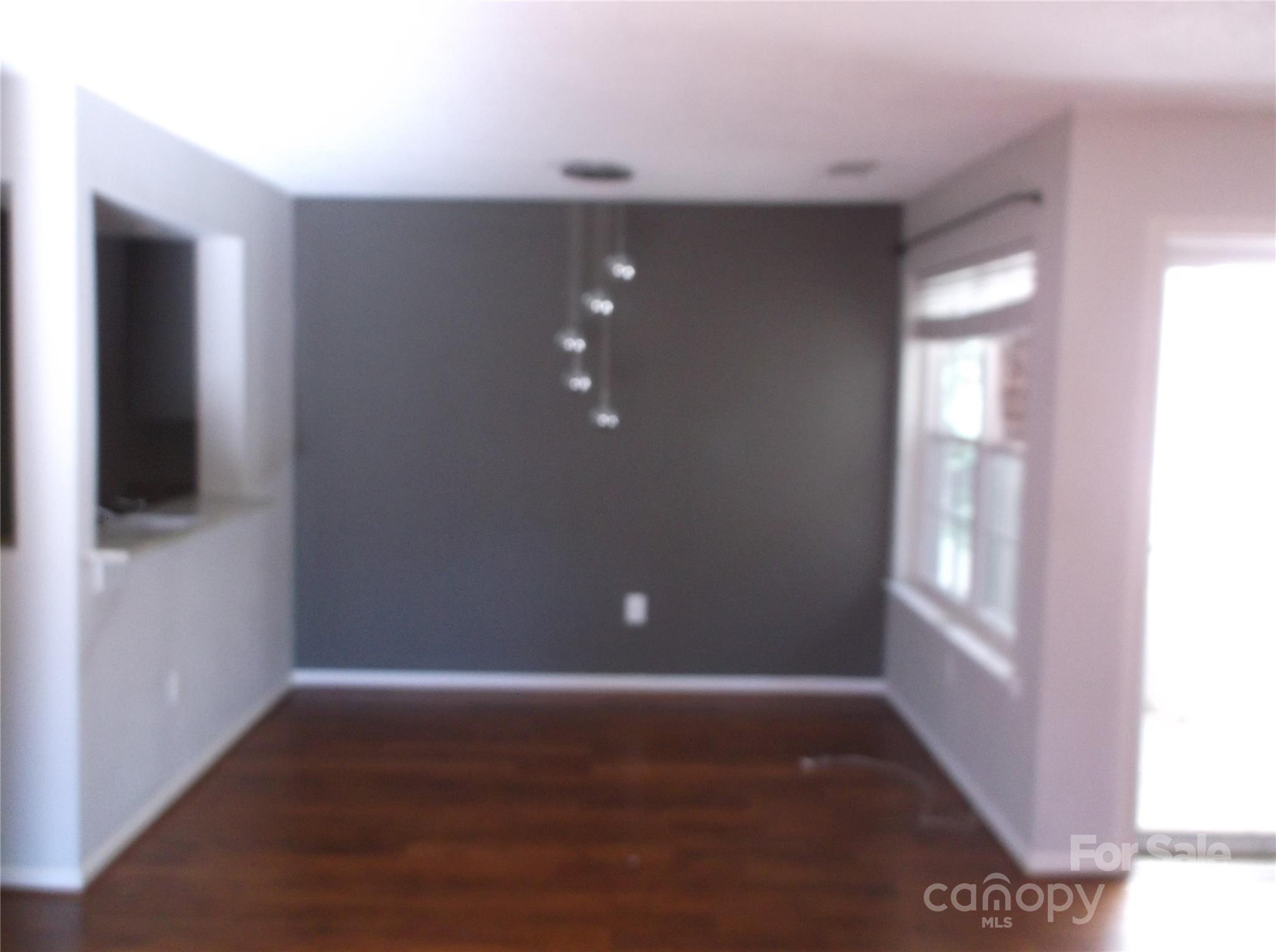 5007 Sharon Road, Unit O Charlotte, NC 28210 - Photo 5 of 20 a view of an empty room with wooden floor and a window