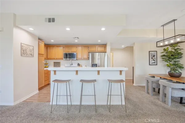 a kitchen with stainless steel appliances granite countertop a refrigerator a stove a sink dishwasher and a refrigerator with wooden floor