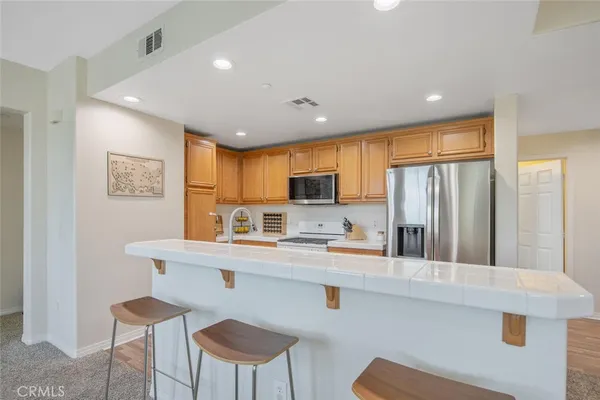 a kitchen with a refrigerator sink and cabinets