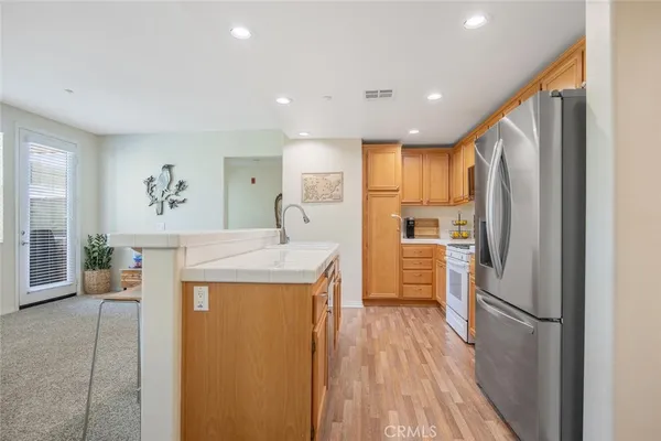 a large white kitchen with lots of counter top space and furniture