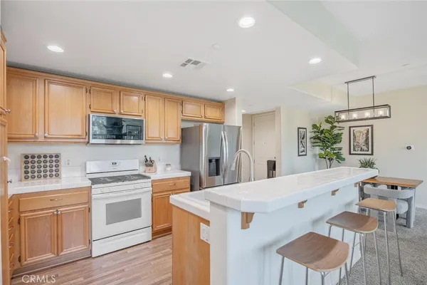 a kitchen with a refrigerator a sink and a stove top oven