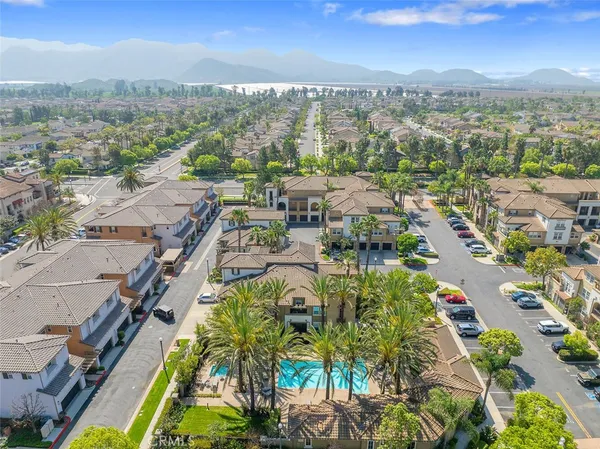 a kitchen with stainless steel appliances kitchen island granite countertop a stove a sink a refrigerator and white cabinets with wooden floor