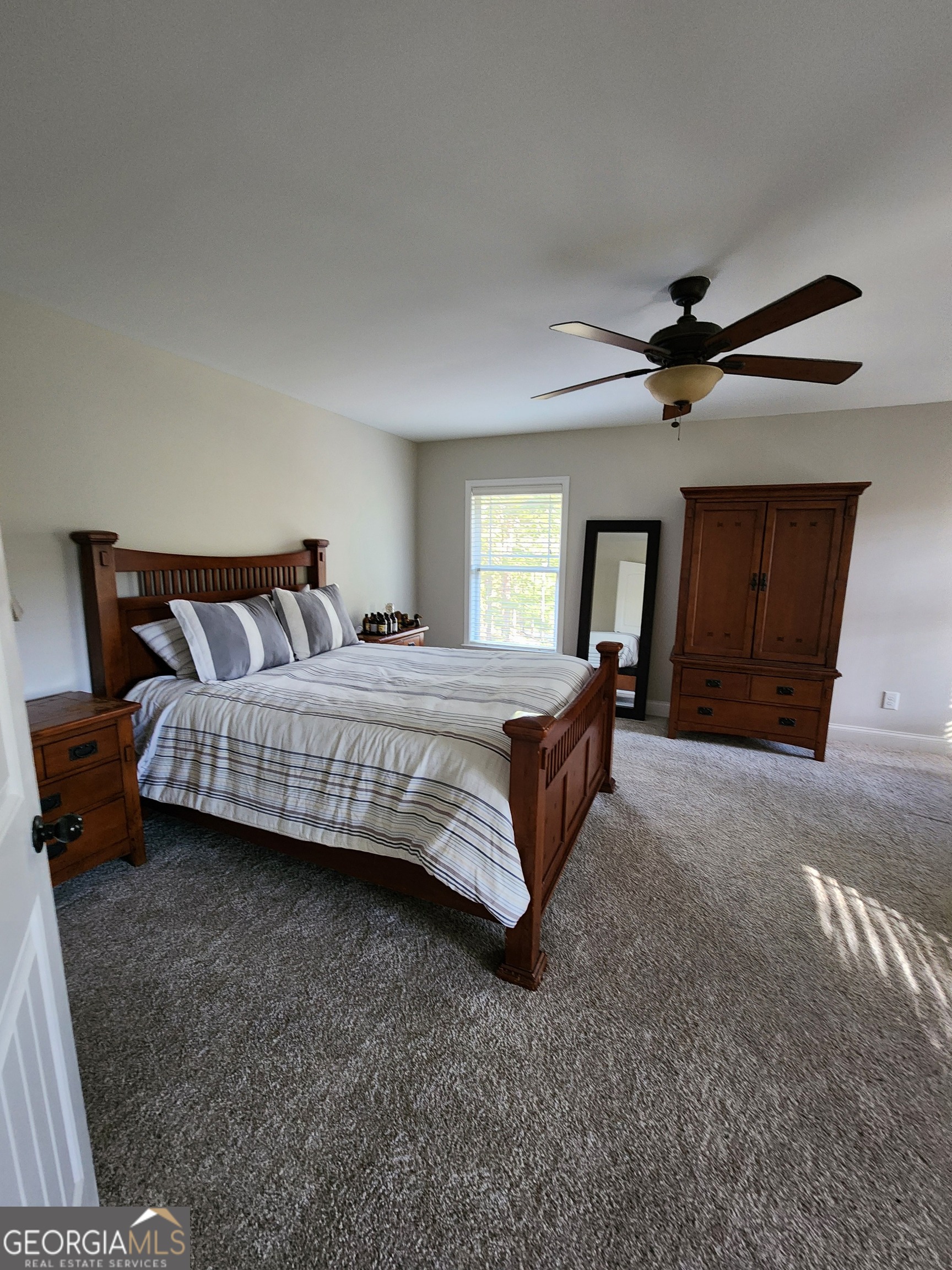 249 Serenity Loop Cataula, GA 31804 - Photo 36 of 44 a bedroom with a bed and a chandelier