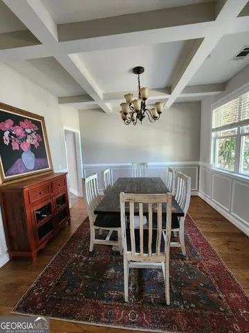 a view of a dining room with furniture a rug and wooden floor