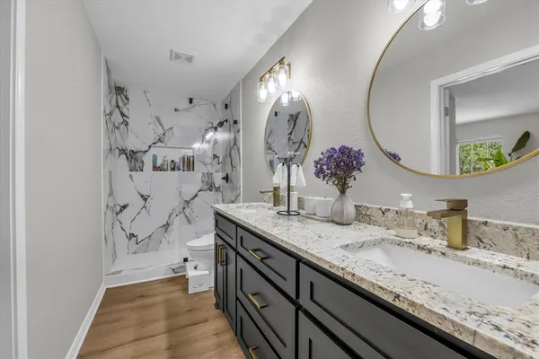 a bathroom with a granite countertop double vanity sinks and a mirror