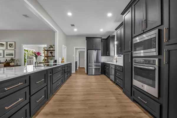 a kitchen with granite countertop a sink and wooden cabinets