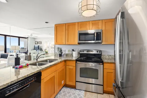 a kitchen with stainless steel appliances granite countertop a stove a sink and a microwave