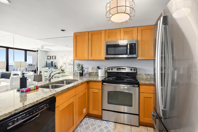 a kitchen with stainless steel appliances granite countertop a stove a sink and a microwave