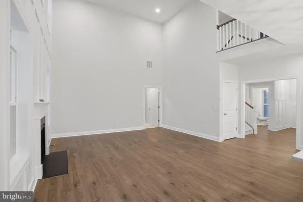 a view of a livingroom with wooden floor and stairs