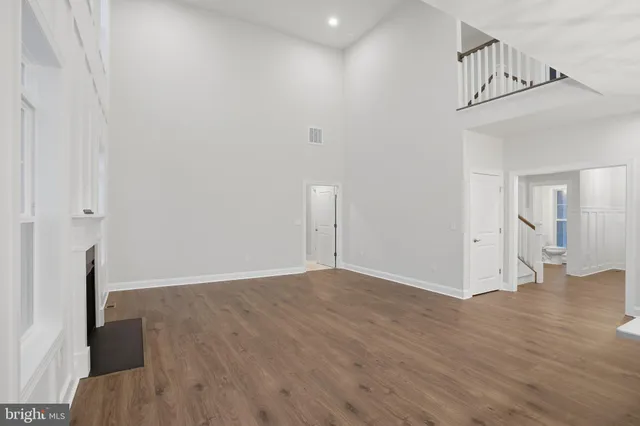 a view of a livingroom with wooden floor and stairs