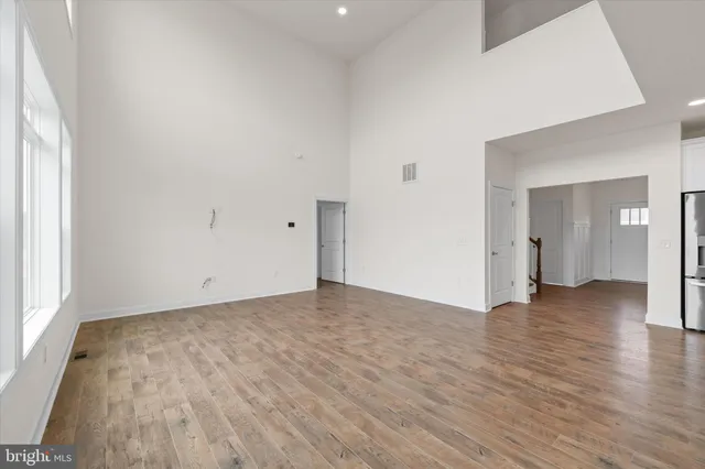 a view of empty room with wooden floor and windows