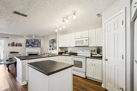 a kitchen with stainless steel appliances granite countertop a sink stove and cabinets