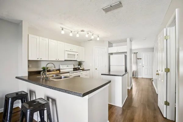 a kitchen with stainless steel appliances granite countertop a refrigerator a stove top oven a sink dishwasher and a refrigerator