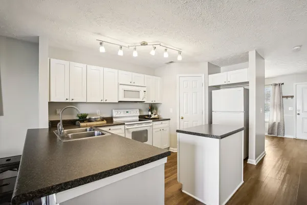 a kitchen with white cabinets and white appliances