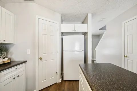 a kitchen with a refrigerator a sink and wooden floor