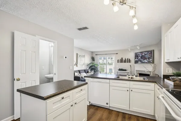 a kitchen with stainless steel appliances granite countertop a sink refrigerator and cabinets