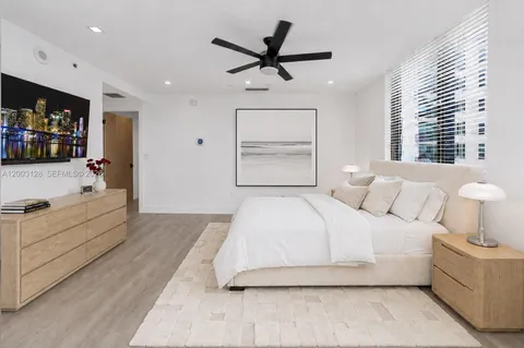 a bedroom with a large bed and a ceiling fan