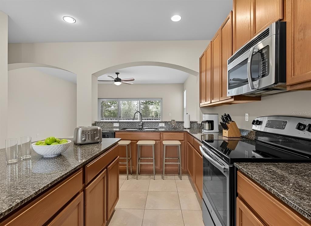800 Callista Cay Loop Tarpon Springs, FL 34689 - Photo 12 of 36 a kitchen with stainless steel appliances granite countertop a sink stove and cabinets