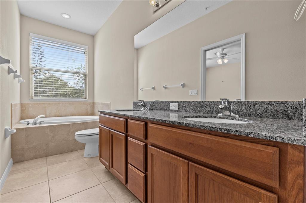 800 Callista Cay Loop Tarpon Springs, FL 34689 - Photo 17 of 36 a bathroom with a granite countertop sink a toilet and bathtub