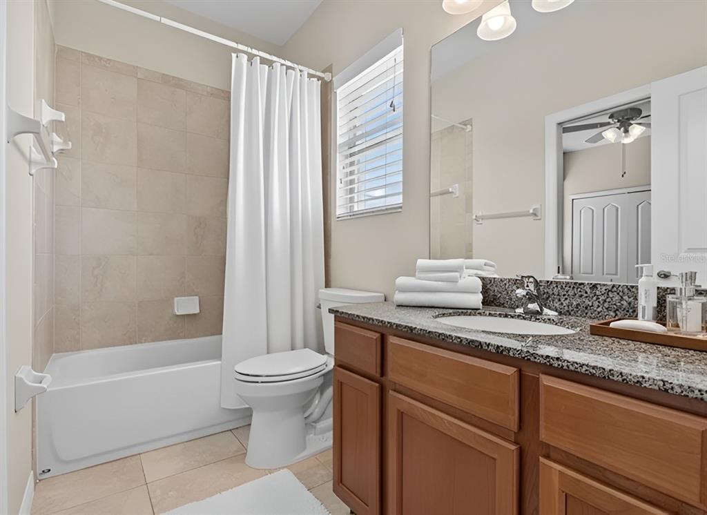 800 Callista Cay Loop Tarpon Springs, FL 34689 - Photo 23 of 36 a bathroom with a granite countertop sink a toilet a mirror and bathtub
