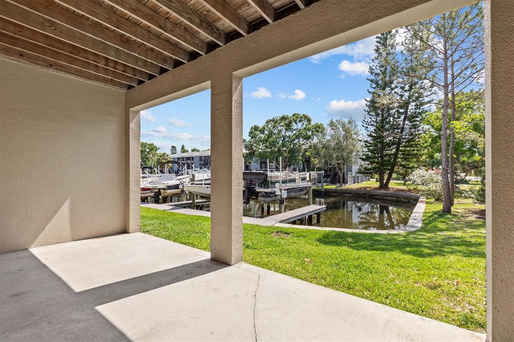 800 Callista Cay Loop Tarpon Springs, FL 34689 - Photo 28 of 36 a view of a backyard with table and chairs and potted plants