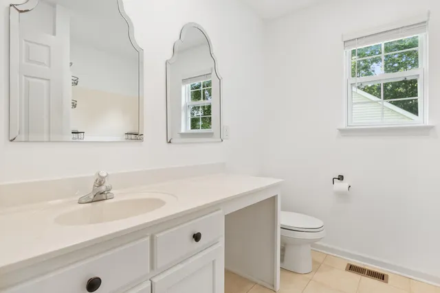 a bathroom with a sink toilet and a mirror