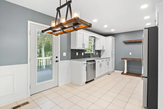 a kitchen with stainless steel appliances granite countertop a stove a sink and a refrigerator