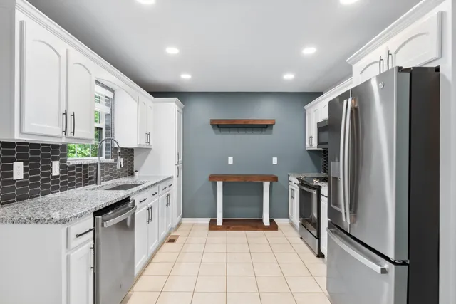 a kitchen with stainless steel appliances granite countertop a refrigerator and a stove