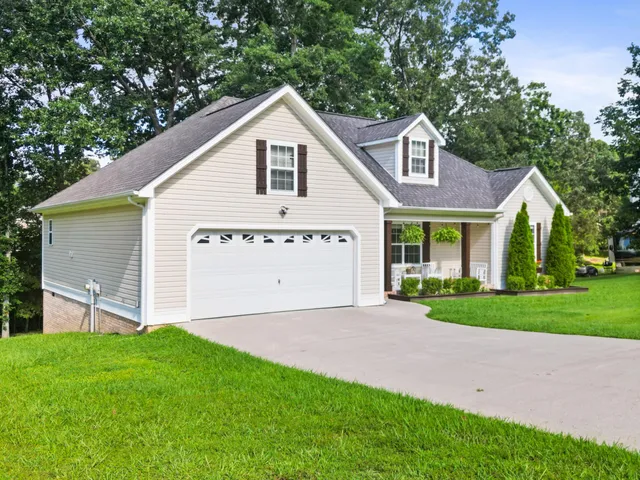 a view of a house with a yard and large tree