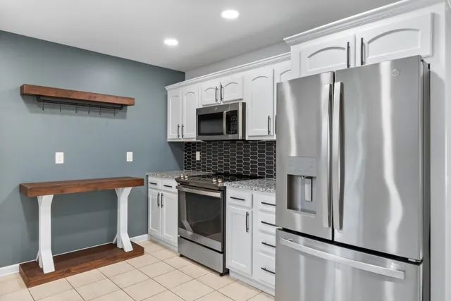 a kitchen with stainless steel appliances a refrigerator sink and microwave
