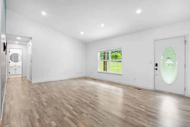 an empty room with wooden floor and mirror