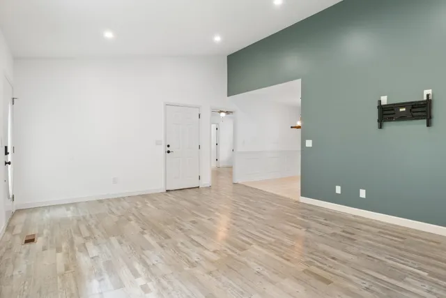 a view of an empty room with wooden floor