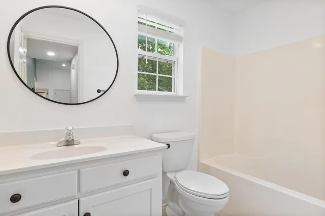 a bathroom with a sink a toilet and a mirror