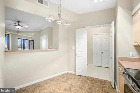 a view of a livingroom with a chandelier fan and kitchen view