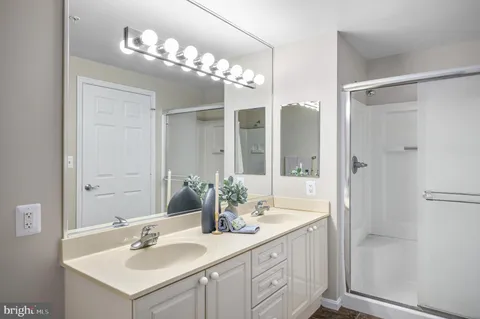 a bathroom with a sink vanity granite shower and a mirror