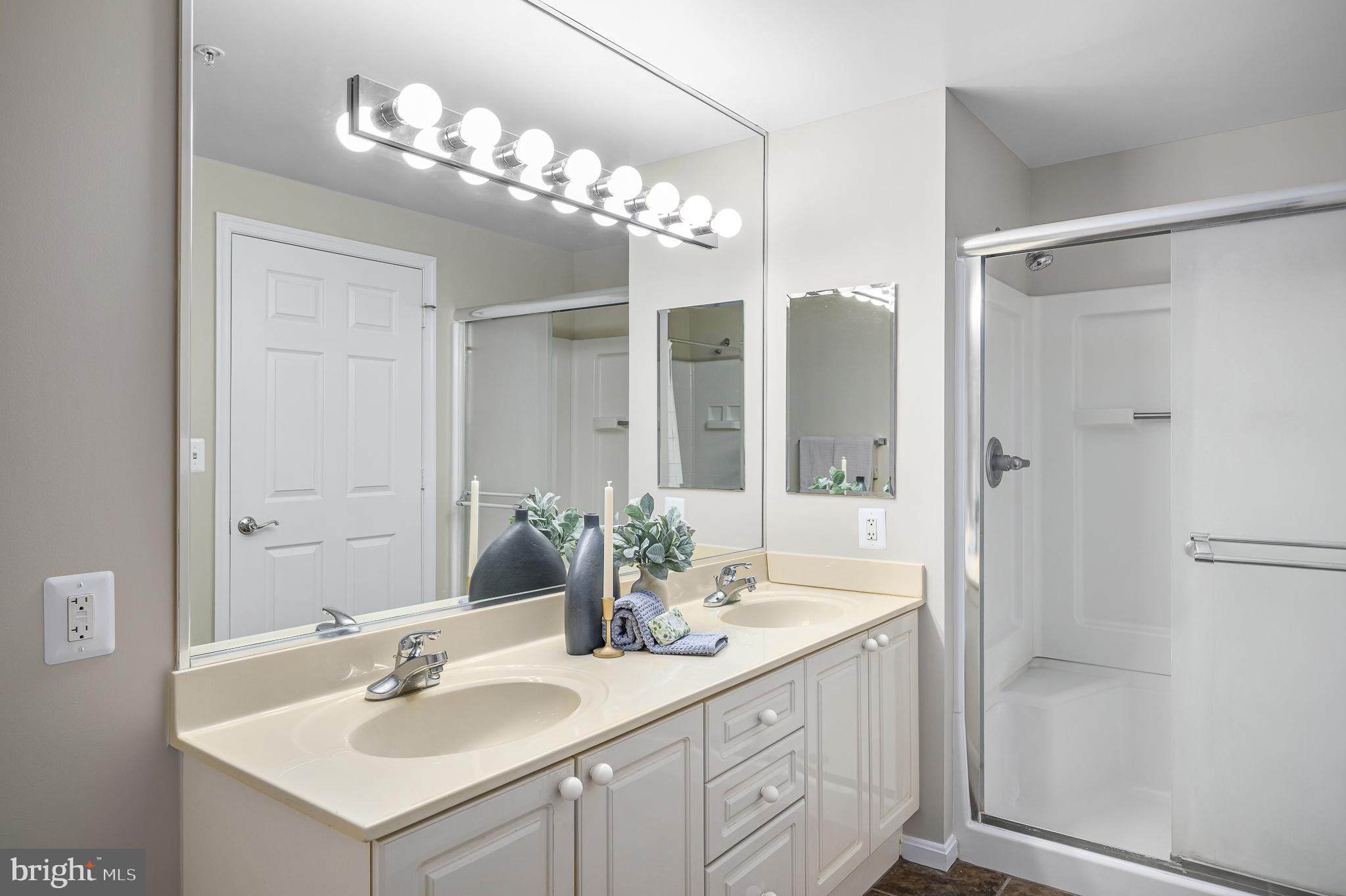 19375 Cypress Ridge Terrace, Unit 114 Leesburg, VA 20176 - Photo 25 of 42 a bathroom with a sink vanity granite shower and a mirror