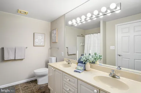 a bathroom with a sink a toilet and a mirror