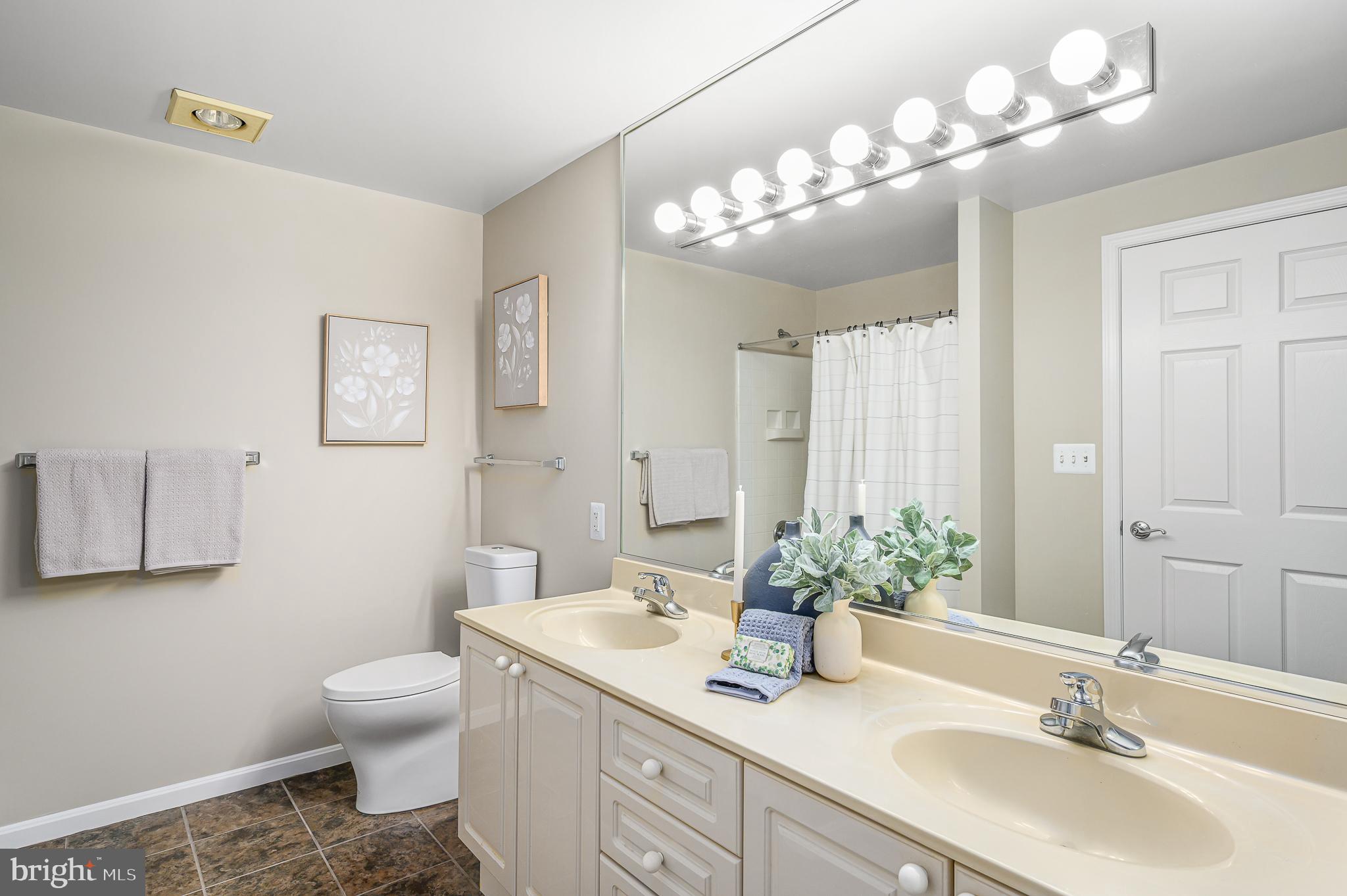 19375 Cypress Ridge Terrace, Unit 114 Leesburg, VA 20176 - Photo 26 of 42 a bathroom with a sink a toilet and a mirror