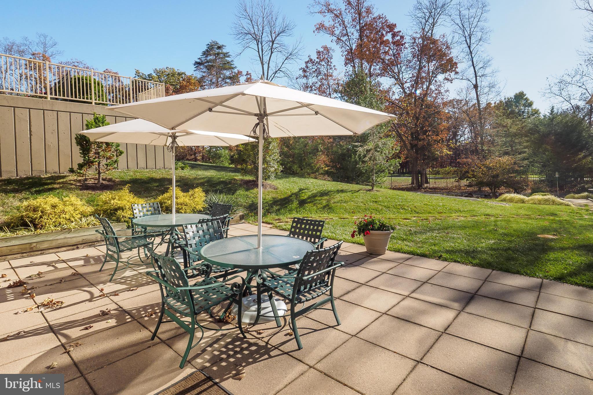 19375 Cypress Ridge Terrace, Unit 114 Leesburg, VA 20176 - Photo 36 of 42 a view of a patio with table and chairs under an umbrella