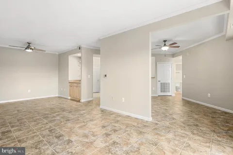 an empty room with a ceiling fan and a window