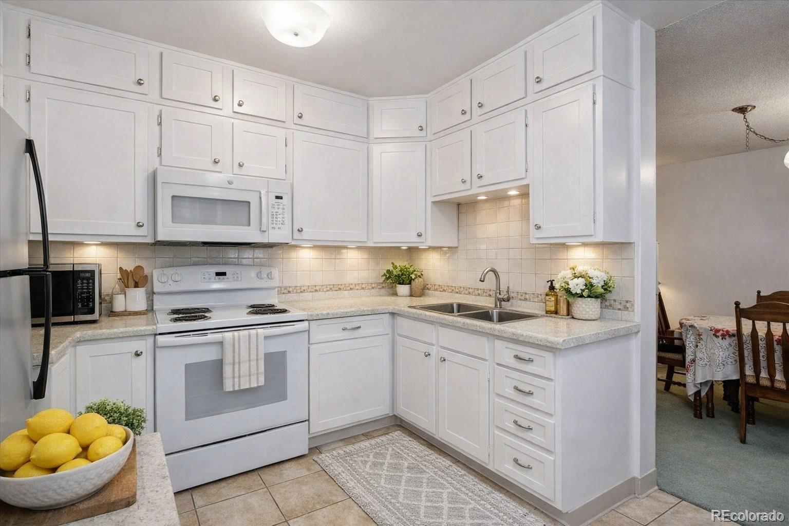 a kitchen with white cabinets and white appliances