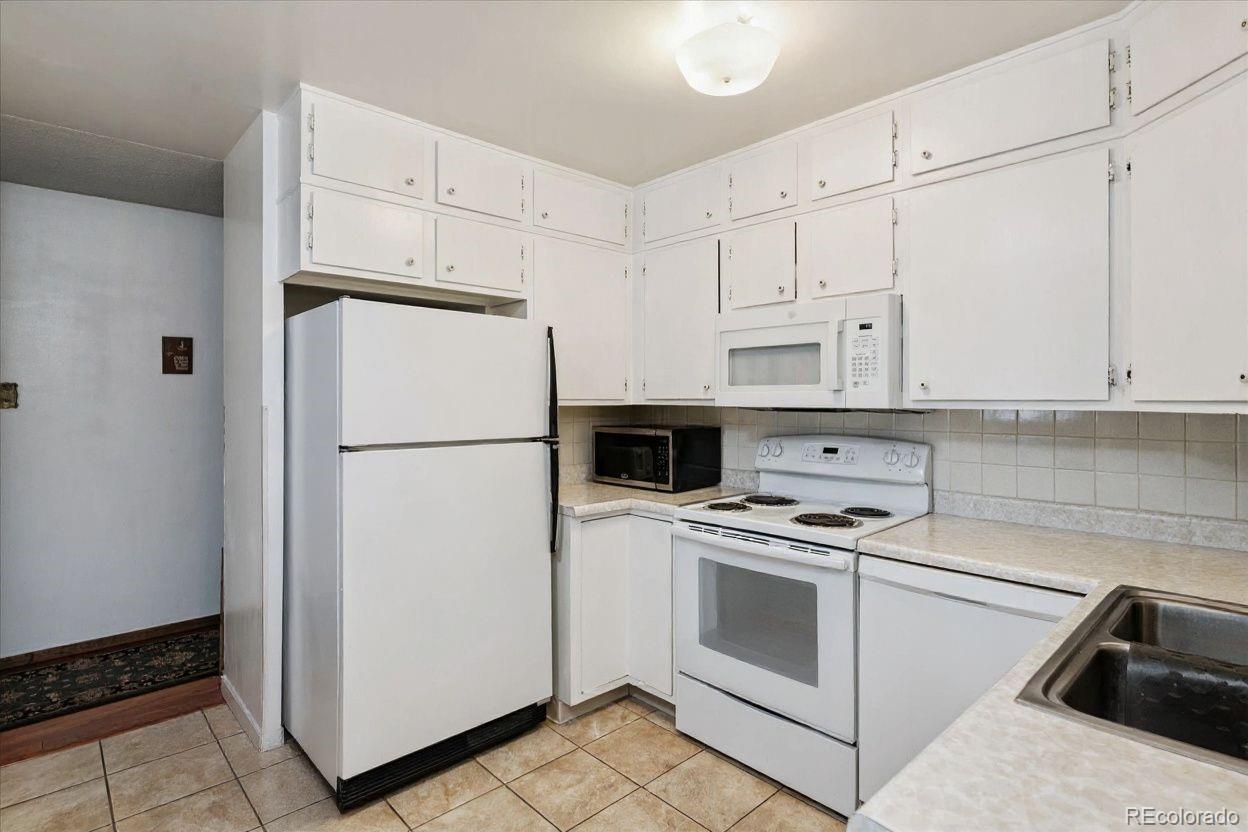 680 South Alton Way, Unit 9B Denver, CO 80247 - Photo 2 of 31 a white refrigerator freezer and a stove sitting inside of a kitchen with granite countertop white cabinets