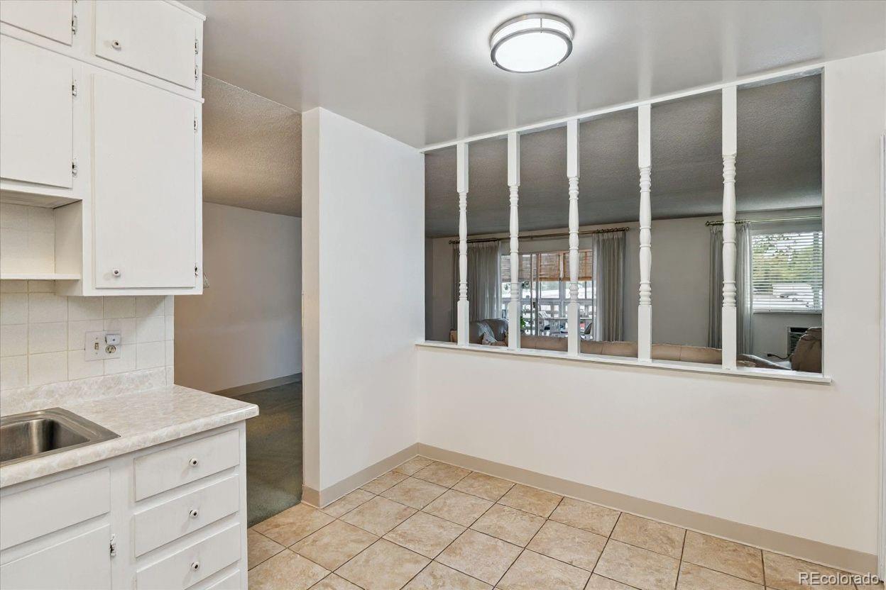 680 South Alton Way, Unit 9B Denver, CO 80247 - Photo 6 of 31 a view of a kitchen with white cabinets and a window
