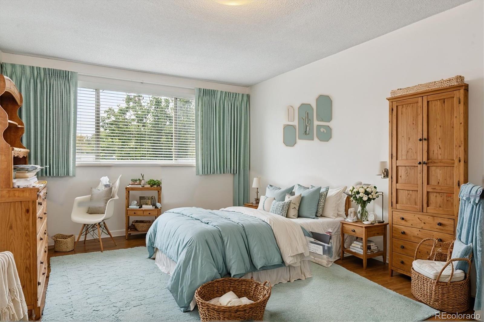 680 South Alton Way, Unit 9B Denver, CO 80247 - Photo 8 of 31 a bedroom with a bed and wooden floor