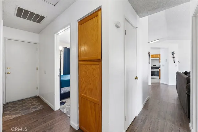 a view of a hallway with wooden floor and closet area
